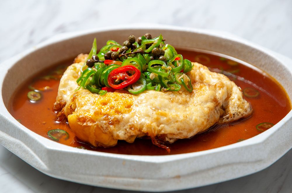 「藤椒炸蛋」(左,360元),融合麻香與酥脆的創意川菜,延續了川菜靈魂的麻香風味,外層酥脆、內餡流心,搭配新鮮青藤椒醬汁,香麻不嗆、餘韻悠長。