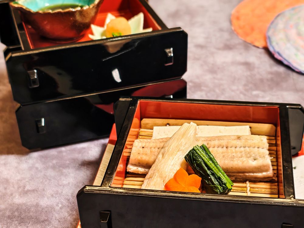 HAYASE日本料理的「鰻魚會席料理」中，「蒸籠鰻魚」是以蒸籠輕蒸保留鰻魚肉質的柔潤與鮮美，搭配柚子胡椒、山葵或特調醬汁，細膩不失層次。