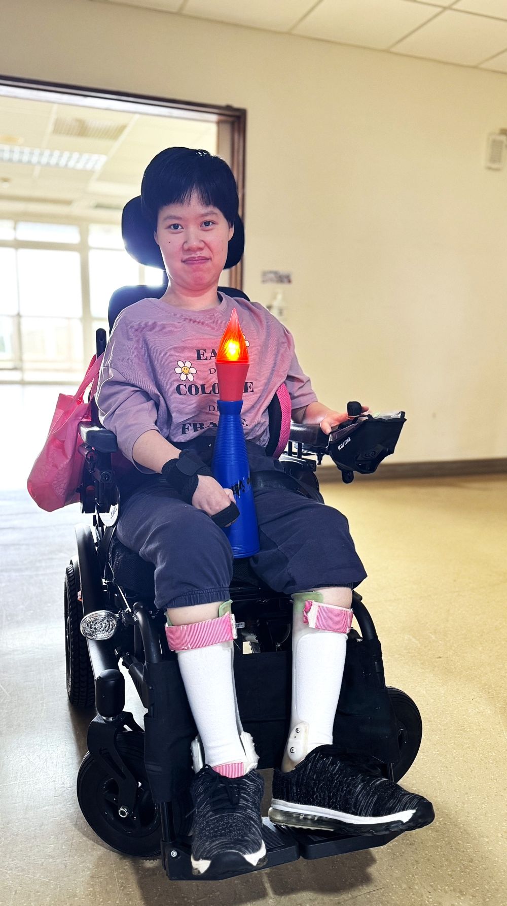 八里愛心教養院運動會規劃聖火進場,由重度腦性麻痺院生小貞擔任火炬手