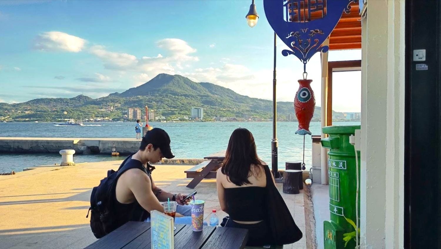 淡水漁文影像館外設有小憩空間邊，邊喝飲品邊欣賞山河美景(陳耀旭館長提供)
