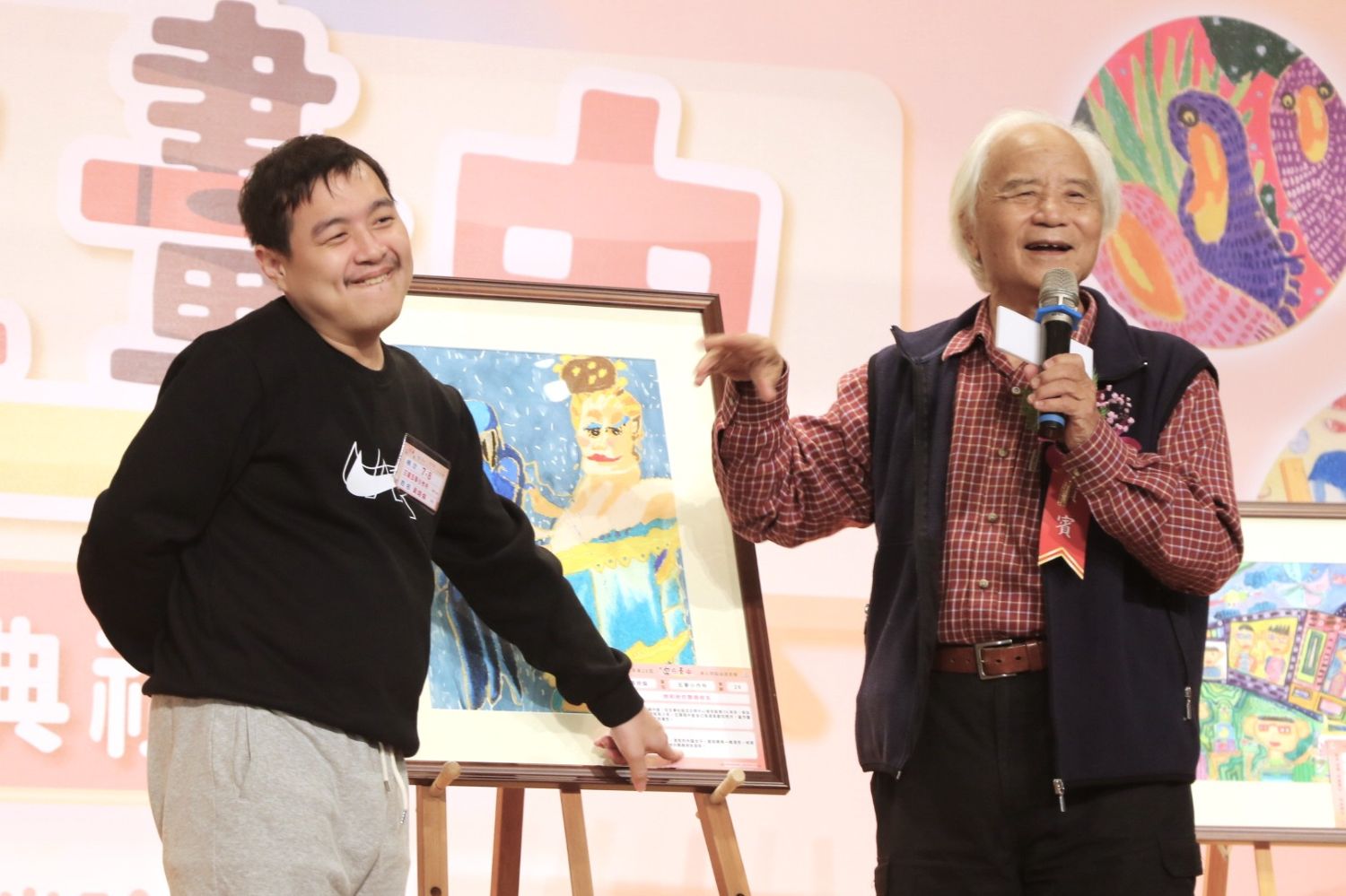 評審委員蘇振明教授(右)說自閉症患者有許多話和心事都說不出口,有如台語「有話無地講」,只有透過畫作才能細細地去傾聽。