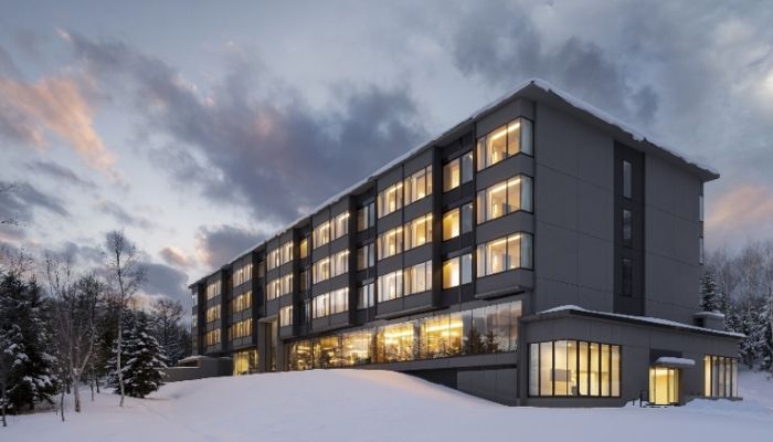 「東山二世谷村麗思卡爾頓飯店」在粉雪群山中格外耀眼，溫暖燈光映照窗景，營造奢華又沉穩的冬季度假氛圍。01