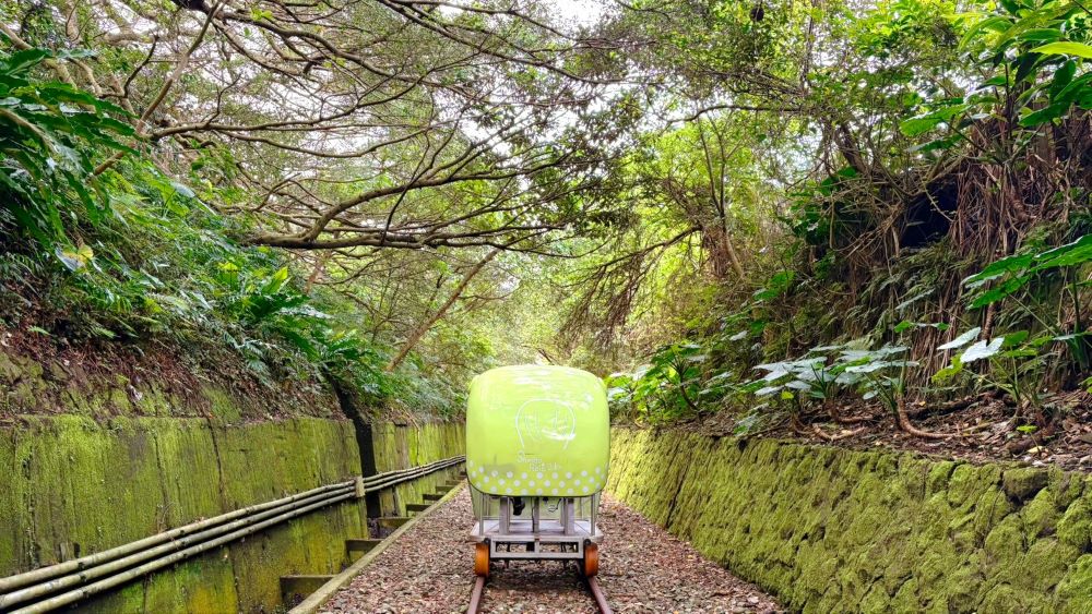 可愛的河豚車穿梭在綠意盎然的鐵道廊帶中，展現出將廢棄軌道成功活化並帶動區域共好的核心價值。