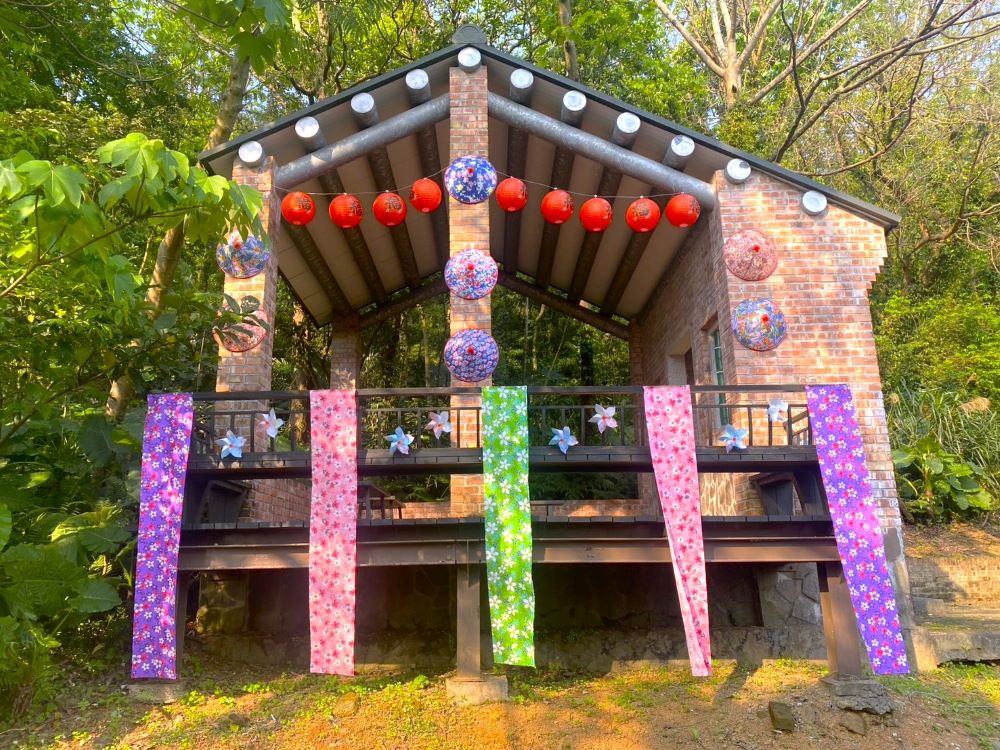 三芝客家奉茶亭裝飾著繽紛的客家花布燈籠與斗笠，在桐花盛開季節時供遊客停駐休息並感受濃厚客家風情