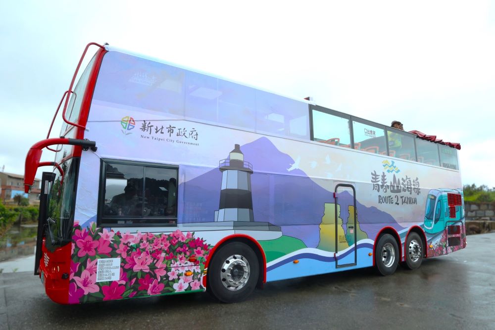 移動的觀景台！青春山海線景觀雙層巴士車身吸睛，彩繪融合野柳女王頭、富貴角燈塔與淡江大橋，滿載新北濱海意象。