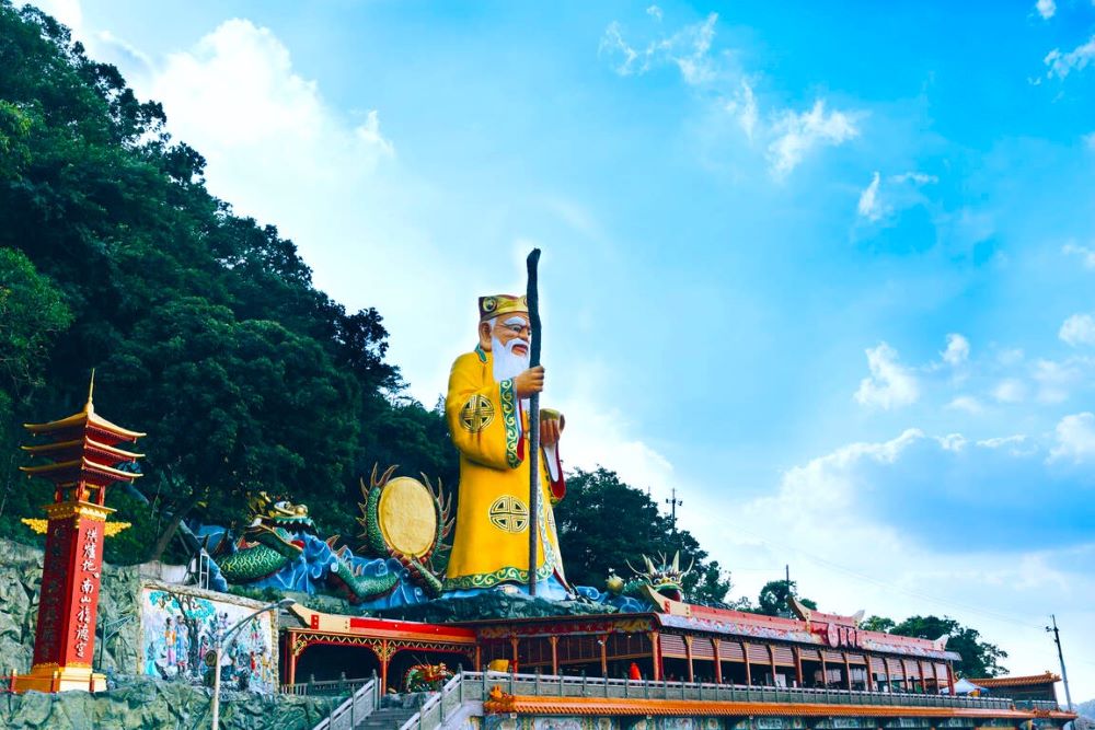遠眺中和烘爐地地標。手持拐杖與金元寶的巨大土地公像，是山林間最莊嚴亮眼的身影。