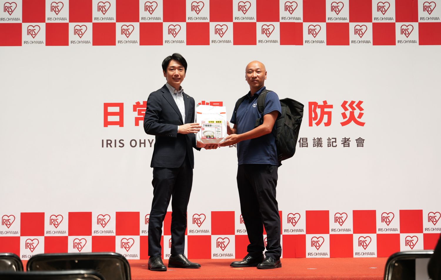 IRIS OHYAMA向社團法人和平之風協會捐贈微波即食白飯及防災背包(左:山本翔/右:鄉家一希)