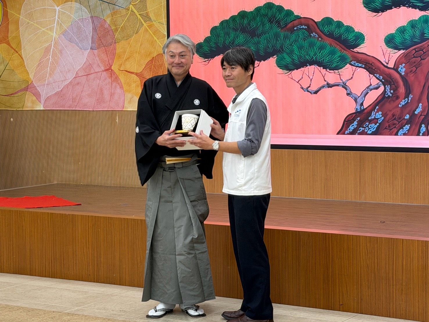 新北市政府教育局何茂田專門委員(右)頒發感謝狀及禮品給,梅若基德大師(左)代表一般財