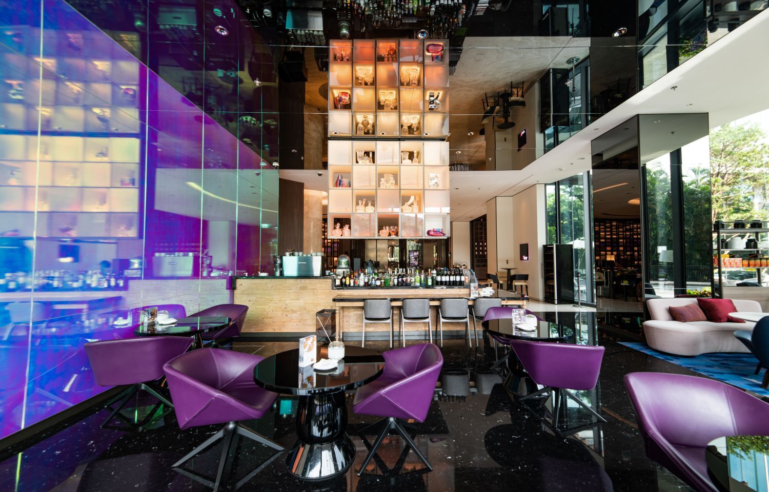 台北士林萬麗酒店 R bar 逸庭以現代設計結合紫色座席與通透空間，營造兼具時尚感與舒適氛圍的酒吧環境。賓客可於此相約小酌，搭配萬聖節限定「鍊金術師」調酒組合，感受節日限定的品飲樂趣